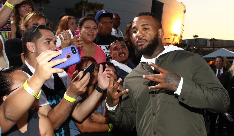 FILE - In this Aug. 10, 2015, file photo, The Game takes a selfie with a fan as he arrives at the Los Angeles premiere of "Straight Outta Compton" at the Microsoft Theater in Los Angeles. (Photo by John Salangsang/Invision/AP, File)