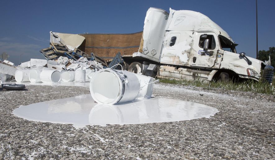 A semi-truck sits on the side of the Indiana Toll Road after a crash near Bristol, Ind., on Wednesday, Aug. 3, 2016. According to Indiana State Trooper Arthur Smith, the truck left the road for an unknown reason and rolled over upon trying to re-enter the road. The truck spilled its contents, 23,000 lbs. of paint according to Smith and the roadway was closed for several hours while crews cleaned it up. ( Sam Householder /The Elkhart Truth via AP) GOSHEN NEWS OUT; MANDATORY CREDIT