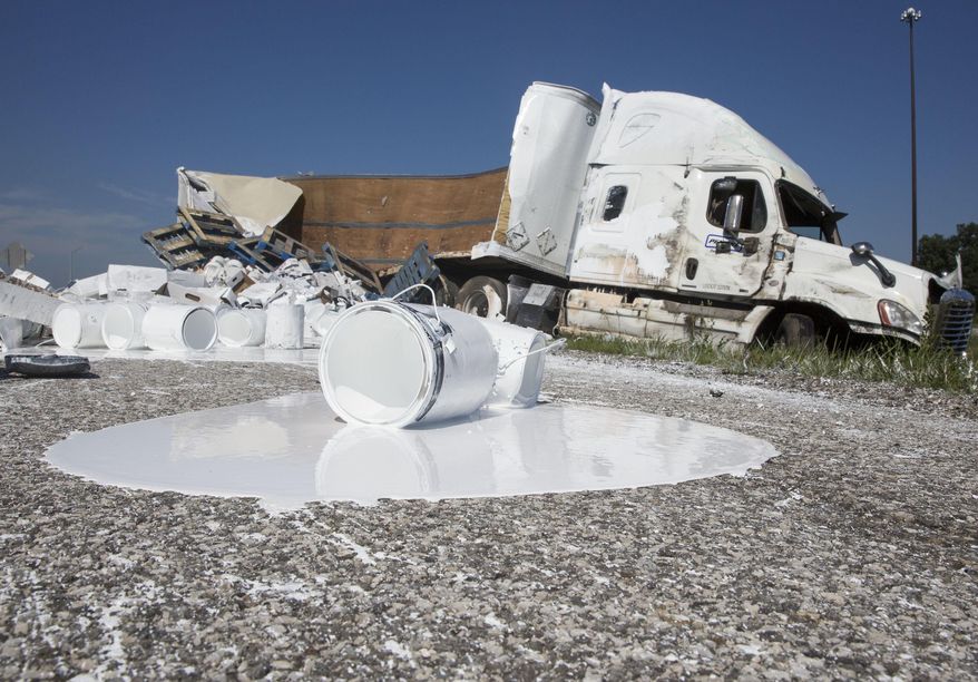 A semi-truck sits on the side of the Indiana Toll Road after a crash near Bristol, Ind., on Wednesday, Aug. 3, 2016. According to Indiana State Trooper Arthur Smith, the truck left the road for an unknown reason and rolled over upon trying to re-enter the road. The truck spilled its contents, 23,000 lbs. of paint according to Smith and the roadway was closed for several hours while crews cleaned it up. ( Sam Householder /The Elkhart Truth via AP) GOSHEN NEWS OUT; MANDATORY CREDIT