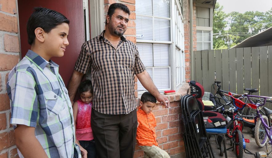 In this July 17, 2016 photo, Ajwad Al Zoubi, second from right, stands on his porch with his children, from left, Naeem, Yman and Ayman, at their apartment in Houston. The family arrived in Houston on March 30, after fleeing Syria via Jordan.  (Jon Shapley/Houston Chronicle via AP)