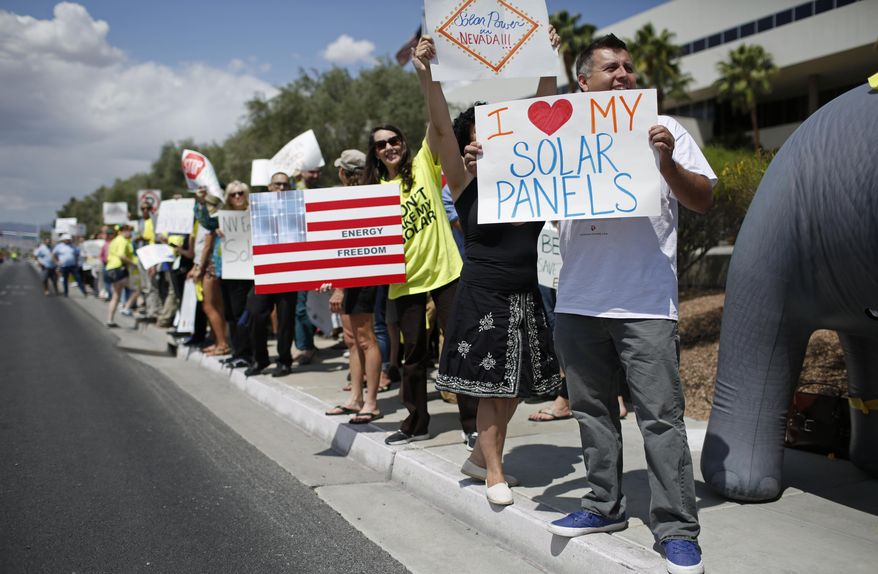 FILE--In this April 22, 2015, file photo, protestors, including Ronald Brittan, right, line up along the street during a rally in front of NV Energy in Las Vegas, Nev. The Nevada Supreme Court has decided not to allow a measure on the statewide ballot in November about rooftop solar electricity rates. Justices ruled Thursday, Aug. 4, 2016, that a referendum by opponents of a 2015 state law was fundamentally flawed. (AP Photo/John Locher, file)