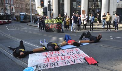 Activists lay on the road outside Nottingham Theatre Royal as they attempt toshut down part of the city centre tram and bus network in Nottingham, England Friday Aug. 5, 2016 to protest for social justice movement Black Lives Matter. Activists affiliated with the U.S.-based group Black Lives Matter have blocked a road leading to Heathrow Airport, and Nottinghamand city centre and in other British cities (Edward Smith/PA via AP)
