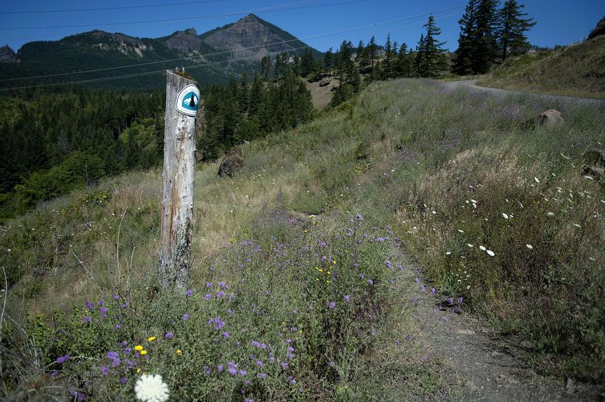 ADVANCE FOR THE WEEKEND OF AUG. 6-7 AND THEREAFTER - In a July 14, 2016 photo, a marker for the Pacific Crest Trail, which runs through Ted Salka's property, is seen in North Bonneville, Wash.. Salka's plans to sell some of his land to the U.S. Forest Service has frustrated local officials. (Amanda Cowan/The Columbian via AP)