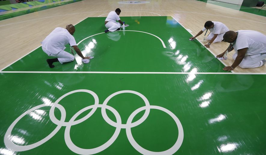 Work crews clean the basketball floor during an off day for women&#39;s basketball at the Youth Center at the 2016 Summer Olympics in Rio de Janeiro, Brazil, Friday, Aug. 5, 2016. The women&#39;s competition begins on Saturday. (AP Photo/Carlos Osorio)