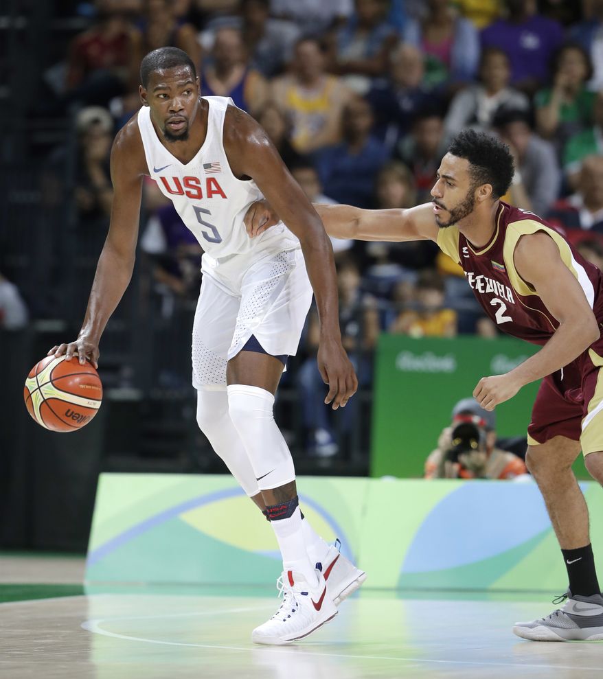 United States' Kevin Durant (5) moves the ball around Venezuela's Dwight Lewis (2) during a men's basketball game at the 2016 Summer Olympics in Rio de Janeiro, Brazil, Monday, Aug. 8, 2016. (AP Photo/Eric Gay)