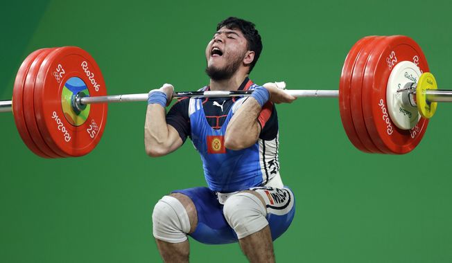 Izzat Artykov, of Kyrgystan, competes in the men&#x27;s 69kg weightlifting competition at the 2016 Summer Olympics in Rio de Janeiro, Brazil, Tuesday, Aug. 9, 2016. (AP Photo/Mike Groll)