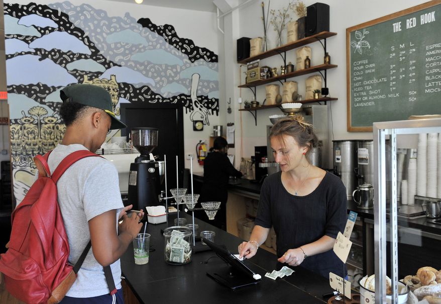 Julia Callis, right, waits on Stephanie Blair, at The Red Hook, a coffee shop on Agnes Street in West Village in Detroit on Tuesday, Aug. 9, 2016. Detroit has started an effort to improve the city's neighborhood main streets and ease bureaucratic hurdles that often stand in the way. (Robin Buckson / The Detroit News via AP)