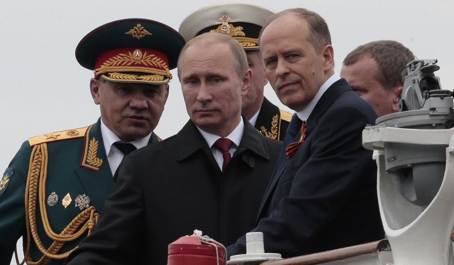 Russian President Vladimir Putin, centre, flanked by Defense Minister Sergei Shoigu, left, and Federal Security Service Chief Alexander Bortnikov, right, arrives on a boat after inspecting battleships during a navy parade marking the Victory Day in Sevastopol, Crimea, Friday, May 9, 2014. (Associated Press) ** FILE **
