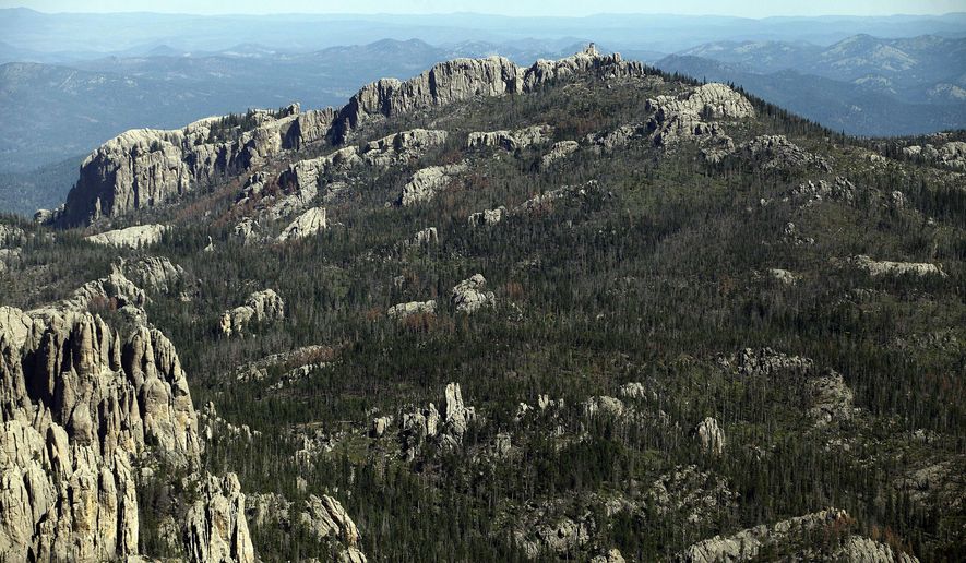 FILE - This Aug. 14, 2014, aerial file photo shows Harney Peak southwest of Hill City, S.D. The recent decision by the U.S. Board on Geographic Names to rename Harney Peak to Black Elk Peak surprised South Dakota's governor, but vindicated activists who unsuccessfully argued to state officials last year that the peak in the Black Hills shouldn't bear the name of a man whose soldiers killed Native Americans. (Chris Huber/Rapid City Journal via AP, File)