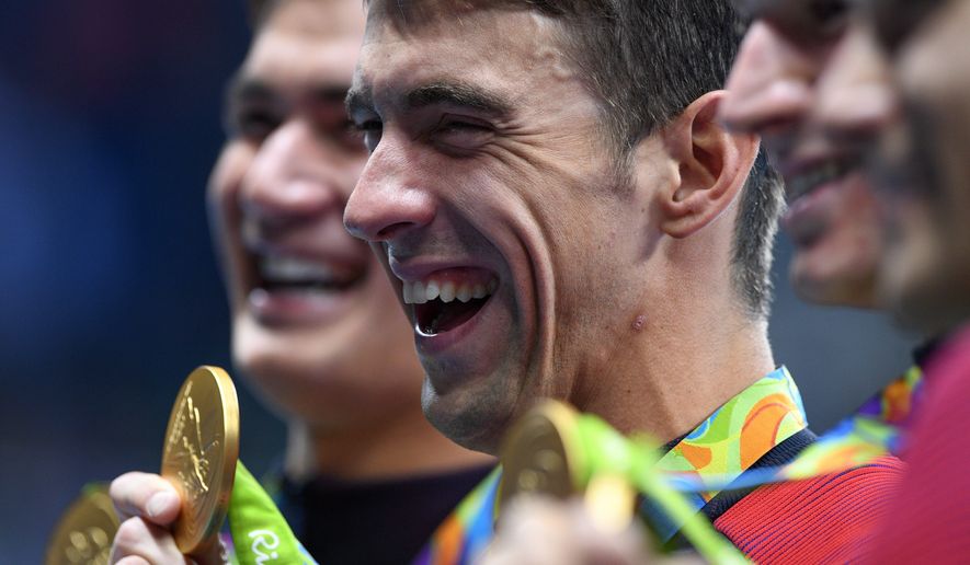 United States&#39; Michael Phelps celebrates with teammates during the medal ceremony for the men&#39;s 4 x 100-meter medley relay final during the swimming competitions at the 2016 Summer Olympics, Sunday, Aug. 14, 2016, in Rio de Janeiro, Brazil. (Sean Kilpatrick/The Canadian Press via AP)