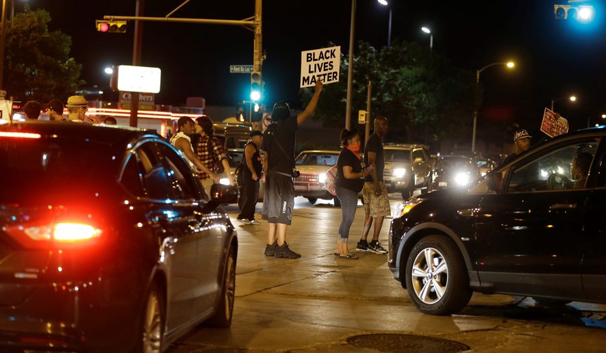 Protesters block traffic at a busy intersection Sunday in Milwaukee. (Associated Press)