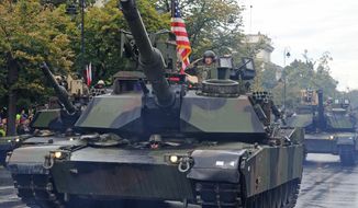 A group of American tanks and soldiers take part in a yearly military parade marking the Polish Army Day, in Warsaw, Poland, Monday, Aug. 15, 2016, in a symbolic show of increased U.S. military involvement in a region shaken by a more assertive Russia. (AP Photo/Alik Keplicz)