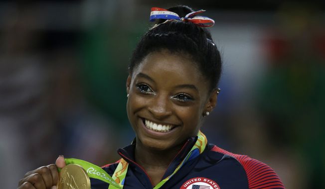 United States&#x27; Simone Biles displays her gold medal for floor during the artistic gymnastics women&#x27;s apparatus final at the 2016 Summer Olympics in Rio de Janeiro, Brazil, Tuesday, Aug. 16, 2016. (AP Photo/Rebecca Blackwell)