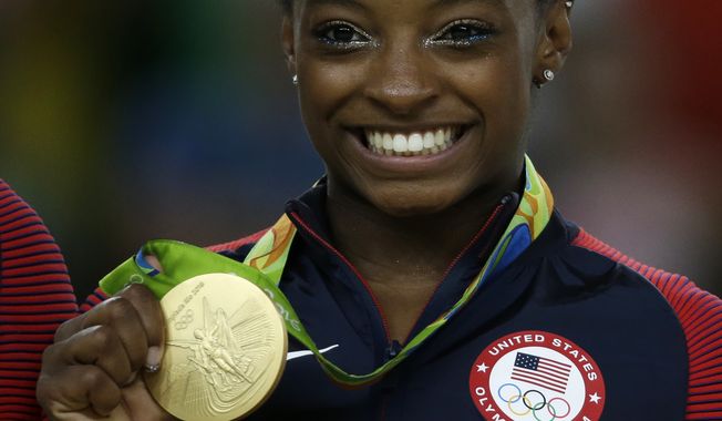 United States&#x27; Simone Biles displays her gold medal for floor during the artistic gymnastics women&#x27;s apparatus final at the 2016 Summer Olympics in Rio de Janeiro, Brazil, Tuesday, Aug. 16, 2016. (AP Photo/Rebecca Blackwell)