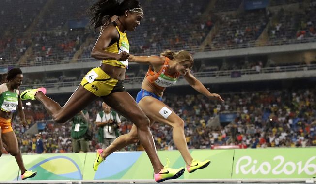 Elaine Thompson, left, from Jamaica crosses the line to win the gold medal in the women&#x27;s 200-meter final during the athletics competitions of the 2016 Summer Olympics at the Olympic stadium in Rio de Janeiro, Brazil, Wednesday, Aug. 17, 2016. (AP Photo/Matt Dunham)