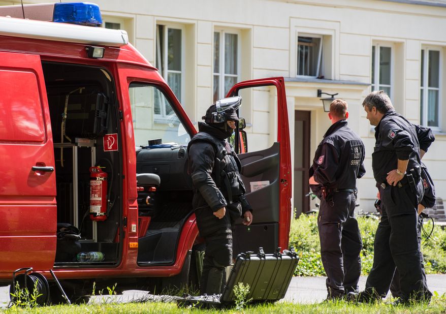 Police guard in front of a house in Eisenhuettenstadt, Germany, Wednesday Aug. 17, 2016. German police arrested a man Wednesday after finding explosives during a raid on his apartment and authorities said he is suspected of planning an attack. The suspect is a 27-year-old German man who lived in the eastern city of Eisenhuettenstadt, Frankfurt an der Oder police told the dpa news agency. Brandenburg governor Dietmar Woidke said police suspect the man of planning an act of terrorism and that he might have contacts to Islamic extremism, dpa reported. (Patrick Pleul/dpa via AP)
