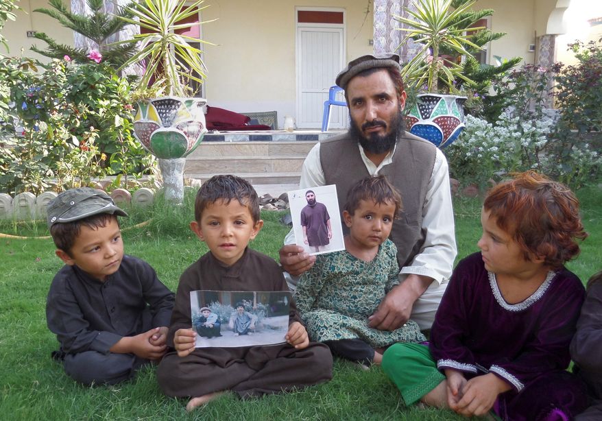 In this Tuesday, Aug. 16, 2016, photo, Fazel Karim, holds a picture of his brother, who was recently released from the Guantanamo Bay detention center, at his home in the village of Haiderkhil, Mandozai district of Khost province, Afghanistan. Obiadullah's family said they're excited their son is among 15 prisoners released from Guantanamo and transferred to the United Arab Emirates this week. They say Obiadullah is now "free" after 14 years in the U.S. prison in Cuba and that they can hardly wait to hear from him. (AP Photo/Nishanuddin Khan)