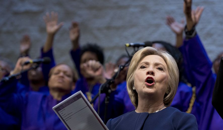 FILE - In this March 13, 2016, file photo, Democratic presidential candidate Hillary Clinton sings during service at Mount Zion Fellowship Church in Highland Hills, Ohio. Black Baptist churches may not seem like an obvious match for Clinton, a white Methodist from the Chicago suburbs. But the Democratic presidential candidate, who has been criticized for her tentative or even awkward political skills, often seems most at ease in these churches where she has shared her faith for many years and earned a loyal following in the process. (AP Photo/Carolyn Kaster, File)