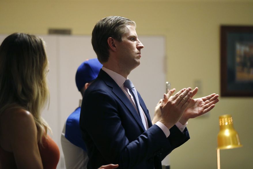 Eric Trump, son of Republican presidential candidate Donald Trump, applauds as Trump speaks to retired and active law enforcement personnel at a Fraternal Order of Police lodge during a campaign stop in Statesville, N.C., Thursday, Aug. 18, 2016. At left is Eric's wife Lara Yunaska. (AP Photo/Gerald Herbert)
