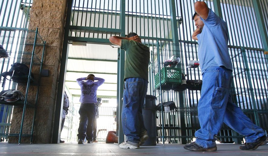 In this Thursday, Aug. 9, 2012, file photo, suspected illegal immigrants are transferred out of the holding area after being processed at the Tucson Sector of the U.S. Customs and Border Protection headquarters in Tucson, Ariz. (AP Photo/Ross D. Franklin, File) 