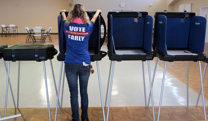 Erika Davidson sets up voting booths at the Panama City Beach Senior Center on Friday, Aug. 19, 2016, in Panama City Beach, Fla. (Heather Leiphart/News Herald via AP)