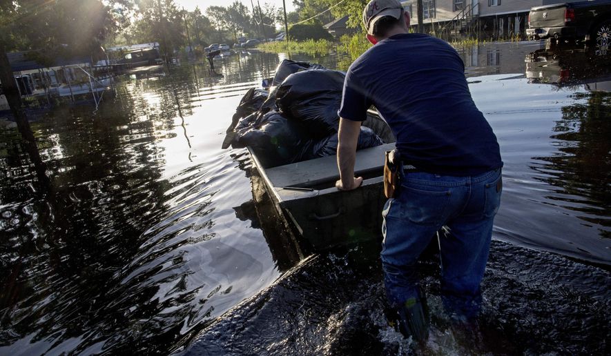 Daniel Stover, 17, moves a boat of personal belongings from a friend&#x27;s home flooded home in Sorrento, La., Saturday, Aug. 20, 2016.  Louisiana continues to dig itself out from devastating floods, with search parties going door to door looking for survivors or bodies trapped by flooding. (AP Photo/Max Becherer)