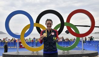 United States&#x27; Gwen Jorgensen celebrates with her gold medal next to the Olympic rings after winning the women&#x27;s triathlon competition of the 2016 Summer Olympics in Rio de Janeiro, Brazil, Saturday, Aug. 20, 2016.   (Jeff Pachoud /Pool Photo via AP) ** FILE **