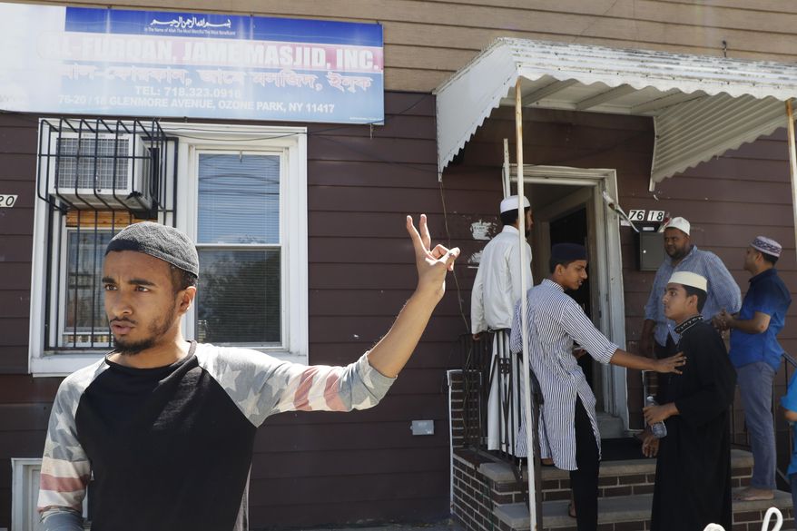 In this Wednesday, Aug. 17, 2016, photo Ashik Uddin gestures as he speaks during an interview with The Associated Press outside the Al-Furqan Jame mosque in the Ozone Park neighborhood of the Queens borough of New York. The shooting of an imam and his assistant near their New York mosque has unnerved Muslim residents of the Ozone Park section of Queens. (AP Photo/Mary Altaffer)
