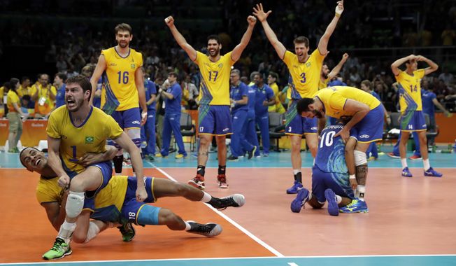 Members of Brazil&#x27;s team celebrates a win after a men&#x27;s gold medal volleyball match against Italy at the 2016 Summer Olympics in Rio de Janeiro, Brazil, Sunday, Aug. 21, 2016. (AP Photo/Matt Rourke)