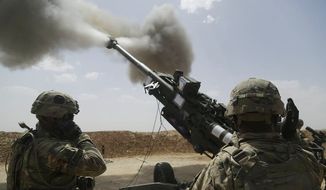 In this file photo, U.S. Army soldiers with 1st Battalion, 320th Field Artillery Regiment, 2nd Brigade Combat Team, 101st Airborne Division (Air Assault), fire an M777 howitzer at Kara Soar Base, Iraq. In March 2021 the 4th Battalion, 319th Artillery Regiment, part of the 173rd Airborne Brigade, will train in France with French-made anti-tank rounds. (Associated Press) **FILE**