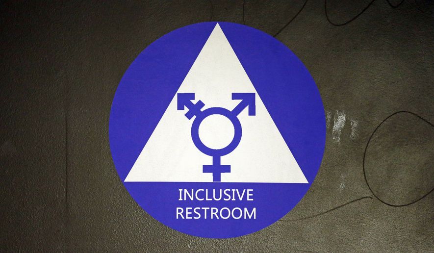 In this May 17, 2016, file photo, a new sticker designates a gender-neutral bathroom at Nathan Hale high school in Seattle.  (AP Photo/Elaine Thompson, File) **FILE**