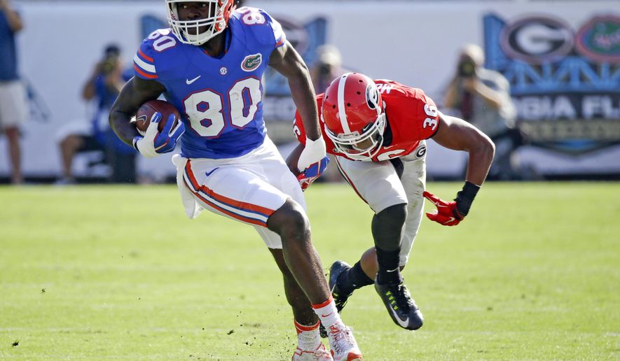 FILE - In this Oct. 31, 2015, file photo, Florida tight end C'yontai Lewis (80) breaks a tackle from Georgia defensive back Rico McGraw, right, after a pass reception in the first half of an NCAA college football game in Jacksonville, Fla. Florida coach Jim McElwain has suspended standout cornerback Jalen Tabor and Lewis on Wednesday, Aug. 17, 2016, saying neither will play in the team's season opener against UMass. (AP Photo/John Raoux, File)