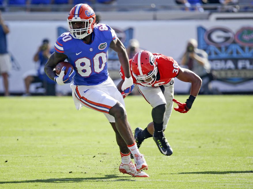 FILE - In this Oct. 31, 2015, file photo, Florida tight end C'yontai Lewis (80) breaks a tackle from Georgia defensive back Rico McGraw, right, after a pass reception in the first half of an NCAA college football game in Jacksonville, Fla. Florida coach Jim McElwain has suspended standout cornerback Jalen Tabor and Lewis on Wednesday, Aug. 17, 2016, saying neither will play in the team's season opener against UMass. (AP Photo/John Raoux, File)