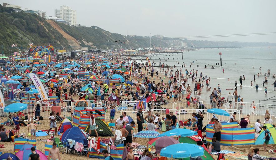 FILE - In this Thursday Aug. 18, 2016, file photo, people gather on a public beach in Bournemouth, England. Global travel spending is still growing, although at a slower pace, despite weakening economies and fears over terrorism, according to a report Monday, Aug. 22, 2016, by the World Travel and Tourism Council. Growth in the United Kingdom is actually expected to exceed the rest of Europe, in 2016. (Andrew Matthews/PA via AP, File)