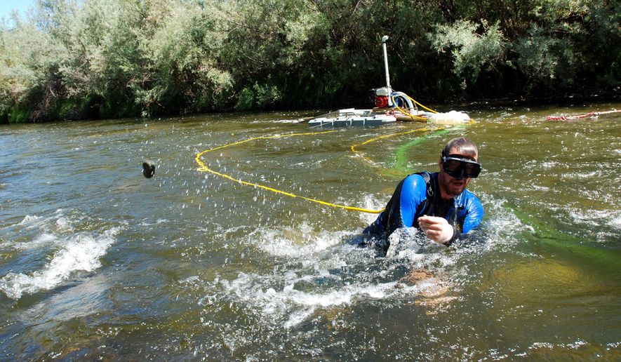 FILE - In this Aug. 5, 2009 file photo, Matt Lauer of Portage, Wis., works a suction dredge to hunt for gold in the Klamath River near Happy Camp, Calif. California's Supreme Court could clear the way for a new era of gold prospectors more than a century after the state's historic Gold Rush. The court is set to rule Monday, Aug. 22, 2016 on the legality of the state's ban on the use of suction dredges to extract gold from rivers. (AP Photo/Jeff Barnard, File)