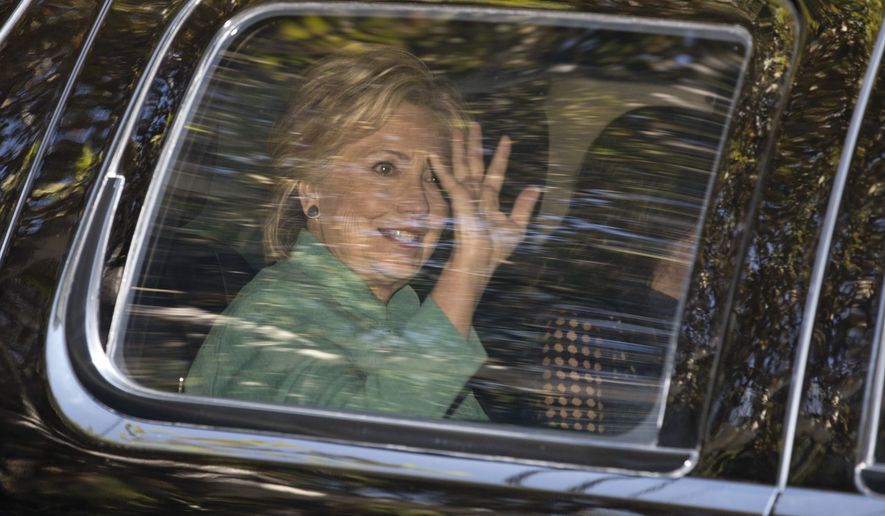 Hillary Clinton waves from her motorcade vehicle as she arrives for a fundraiser at the home of Justin Timberlake and Jessica Biel in Los Angeles on Tuesday. (Associated Press)