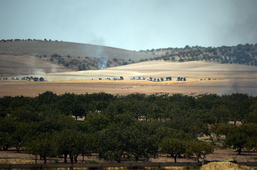 Turkish army tanks and Turkey-backed Syrian opposition forces move toward the Syrian border as pictured from Karkamis, Turkey, Wednesday, Aug. 24, 2016. Turkey's military launched an operation before dawn Wednesday to clear a Syrian border town from Islamic State militants, and a private Turkish TV station reported that a small number of Turkish special forces had crossed into Syria as part of the operation.The operation was launched hours before Vice President Joe Biden was due in Ankara for talks that include developments in Syria.(AP Photo)
