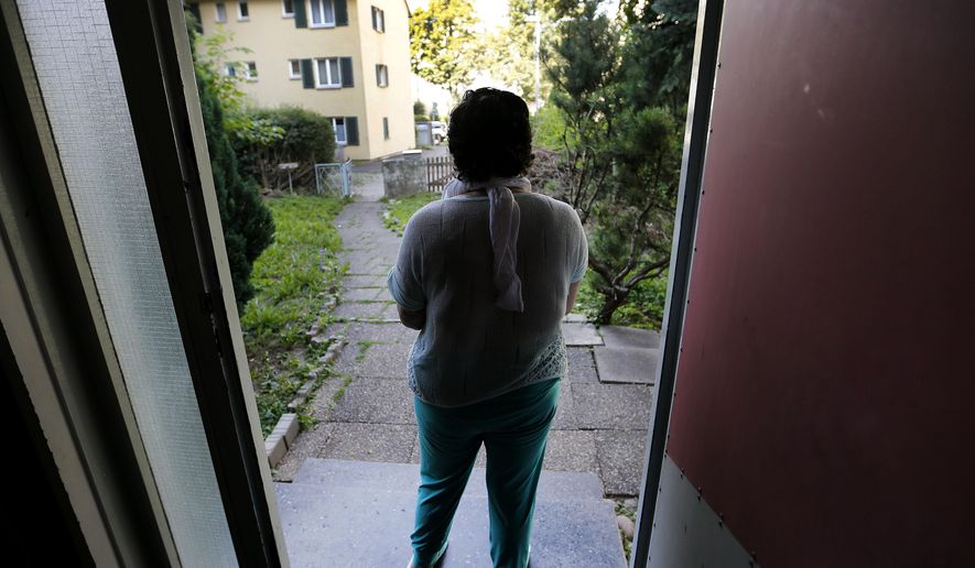 In this July 28, 2016 picture 17-year-old Yazidi girl Yasmin stands in the entrance of her home in Germany. After escaping the clutches of Islamic State, Yasmin, a Yazidi girl, was so traumatized by her captivity that she poured gasoline on herself and set it alight - hoping to render herself no longer desirable to the extremists. Two years later, she’s being treated in Germany not only for her physical wounds, but for the psychological damage that led her to her act of desperation. (AP Photo/Michael Probst)