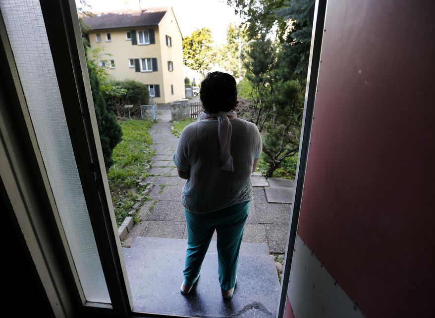 In this July 28, 2016 picture 17-year-old Yazidi girl Yasmin stands in the entrance of her home in Germany. After escaping the clutches of Islamic State, Yasmin, a Yazidi girl, was so traumatized by her captivity that she poured gasoline on herself and set it alight - hoping to render herself no longer desirable to the extremists. Two years later, she’s being treated in Germany not only for her physical wounds, but for the psychological damage that led her to her act of desperation. (AP Photo/Michael Probst)
