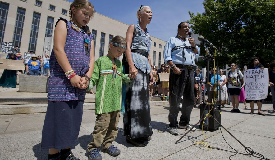 Members of the Lakota people, Timothy Swallow, right, his wife Karan, second from right, and their children Naimah, 8, and Tas, 6, sing the native spiritual song during a rally outside the US District Court in Washington, Wednesday, Aug. 24, 2016, in solidarity with the Standing Rock Sioux Tribe in their lawsuit against the Army Corps of Engineers to protect their water and land from the Dakota Access Pipeline. A federal judge in Washington considered a request by the Standing Rock Sioux for a temporary injunction against an oil pipeline under construction near their reservation straddling the North Dakota-South Dakota border. The Sioux are challenging the Army Corps of Engineers&#39; decision to grant permits for the $3.8 billion pipeline that is intended to carry oil from North Dakota to Illinois. (AP Photo/Manuel Balce Ceneta)