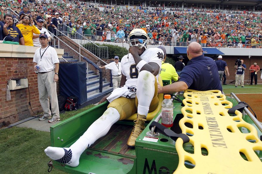 FILE - In this Sept. 12, 2015, file photo, Notre Dame quarterback Malik Zaire (8) is driven off the field after injuring his right ankle during an NCAA college football game against Virginia, in Charlottesville, Va. Recent history suggests several teams will spend the first couple of weeks sorting out their quarterback situation after their starters are knocked out for the remainder of the year. (AP Photo/Andrew Shurtleff, File)