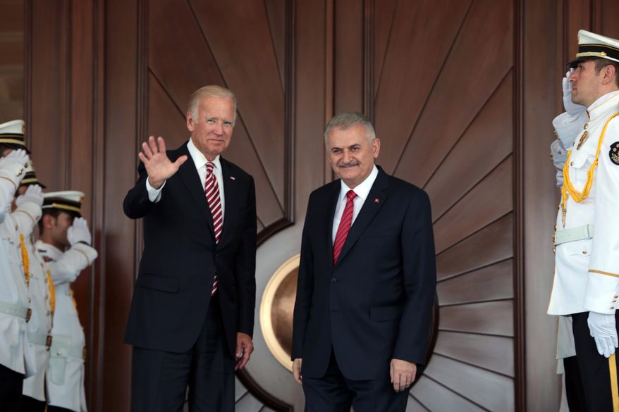 U.S Vice President Joe Biden, left, waves after he was greeted by Turkish Prime Minister Binali Yildirim in Ankara, Turkey, Wednesday, Aug. 24, 2016. Biden has arrived in Ankara for talks with Turkish leaders as Turkey launched a military operation to clear a Syrian border town of Islamic State militants. The visit comes at a difficult time for ties between the two NATO allies.(AP Photo/Burhan Ozbilici)