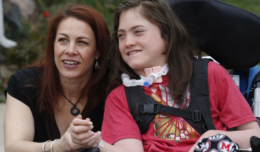 FILE - In this Sunday, April 10, 2016, file photograph, Stacey Linn jokes with her 15-year-old son, Jack Splitt, outside their home in Lakewood, Colo. The teenager, who died Wednesday, Aug. 24, 2016, was the inspiration for "Jack's Law" which gives Colorado school districts the authority to write policies for how and where students can receive medical marijuana treatments on campus. (AP Photo/David Zalubowski, file)