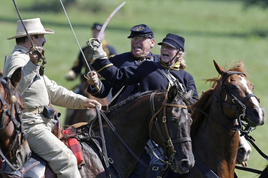 In this June 29, 2013, file photo, reenactors demonstrate a cavalry battle to commemorate the 150th anniversary of the Battle of Gettysburg at Bushey Farm in Gettysburg, Pa. (AP Photo/Matt Rourke, File) ** FILE **