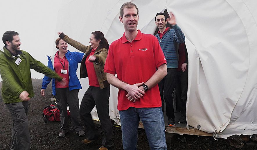 In this photo provided by the University of Hawaii, six scientists celebrate as they exit from their Mars simulation habitat on slopes of Mauna Loa on the Big Island, Hawaii, Sunday, Aug. 28, 2016. The scientists completed a yearlong Mars simulation in Hawaii on Sunday, where they lived in the dome in near isolation. (University of Hawaii via AP)
