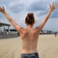 In this July 30, 2015 photo, Kia Sinclair, stands topless on Hampton Beach in Hampton, N.H. In a June 6 memo, the Ocean City [Md.] Beach Patrol said that workers should document complaints of toplessness, but they shouldn&#39;t approach offending sunbathers to rebuke them. (Rich Beauchesne/Portmsouth Herald via AP) **FILE**