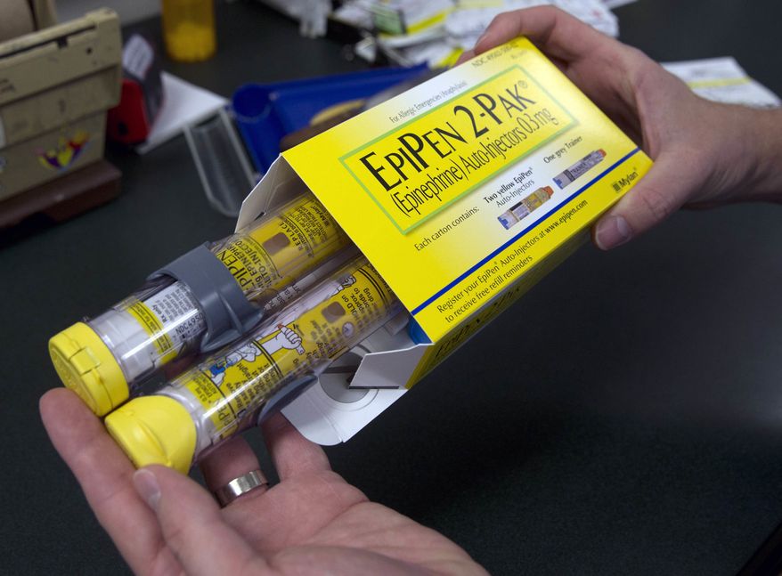 In this July 8, 2016, file photo, a pharmacist holds a package of EpiPens epinephrine auto-injector, a Mylan product, in Sacramento, Calif. Mylan said it will make available a generic version of its EpiPen, as criticism mounts over the price of its injectable medicine. (AP Photo/Rich Pedroncelli, File)