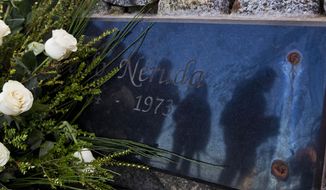 Journalists are reflected on the tombstone of Chile&#39;s Nobel Prize-winning poet Pablo Neruda after he was reburied at his home, now a museum, on Isla Negra, Chile, Tuesday, April 26, 2016. Neruda&#39;s body was exhumed in 2013 for a fourth time in an effort to clear up four decades of suspicion about how the poet died in the days after Chile&#39;s military coup. The results of the analysis will be delivered on May 5. (AP Photo/Esteban Felix)