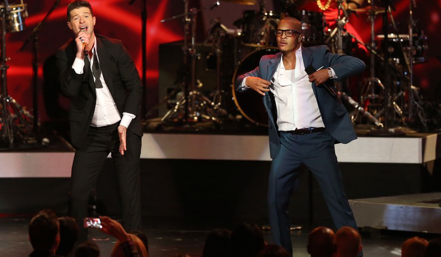 Robin Thicke, left, and T.I. perform "Blurred Lines" at the Grammy Nominations Concert Live! at the Nokia Theatre L.A. Live in Los Angeles in this Dec. 6, 2013 file photo. More than 200 musicians filed a brief with the Ninth Circuit Court of Appeals on Tuesday, Aug. 30, 2016, to express concern about the ruling last year in a case brought by the children of Marvin Gaye, who sued for copyright infringement claiming "Blurred Lines" copied Gaye's hit "Got to Give it Up." (Photo by Matt Sayles/Invision/AP, File) **FILE**