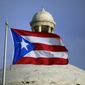 In this July 29, 2015, file photo, the Puerto Rican flag flies in front of Puerto Rico&#x27;s Capitol as in San Juan, Puerto Rico. (AP Photo/Ricardo Arduengo, File)